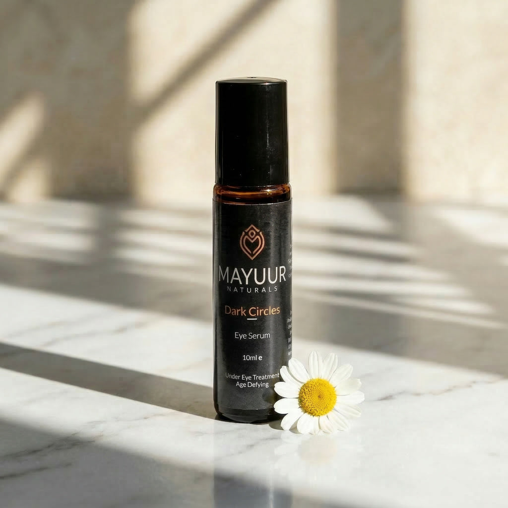 Mayuur Naturals eye serum bottle on a marble surface with a white flower.