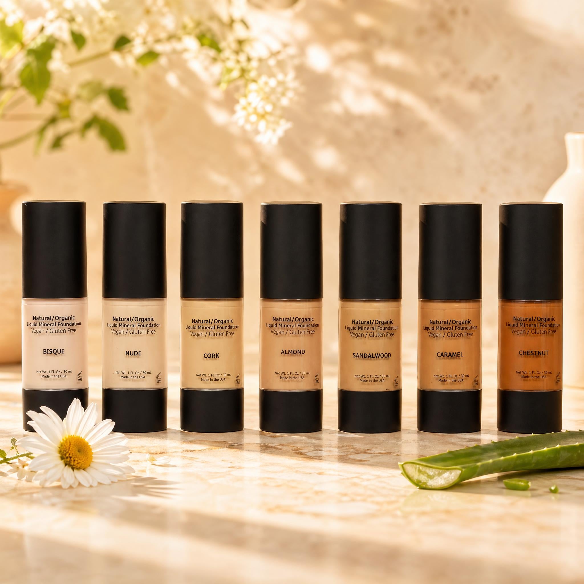 Row of foundation bottles with visible labels on a neutral background
