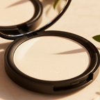 Compact powder in a black case on a light background