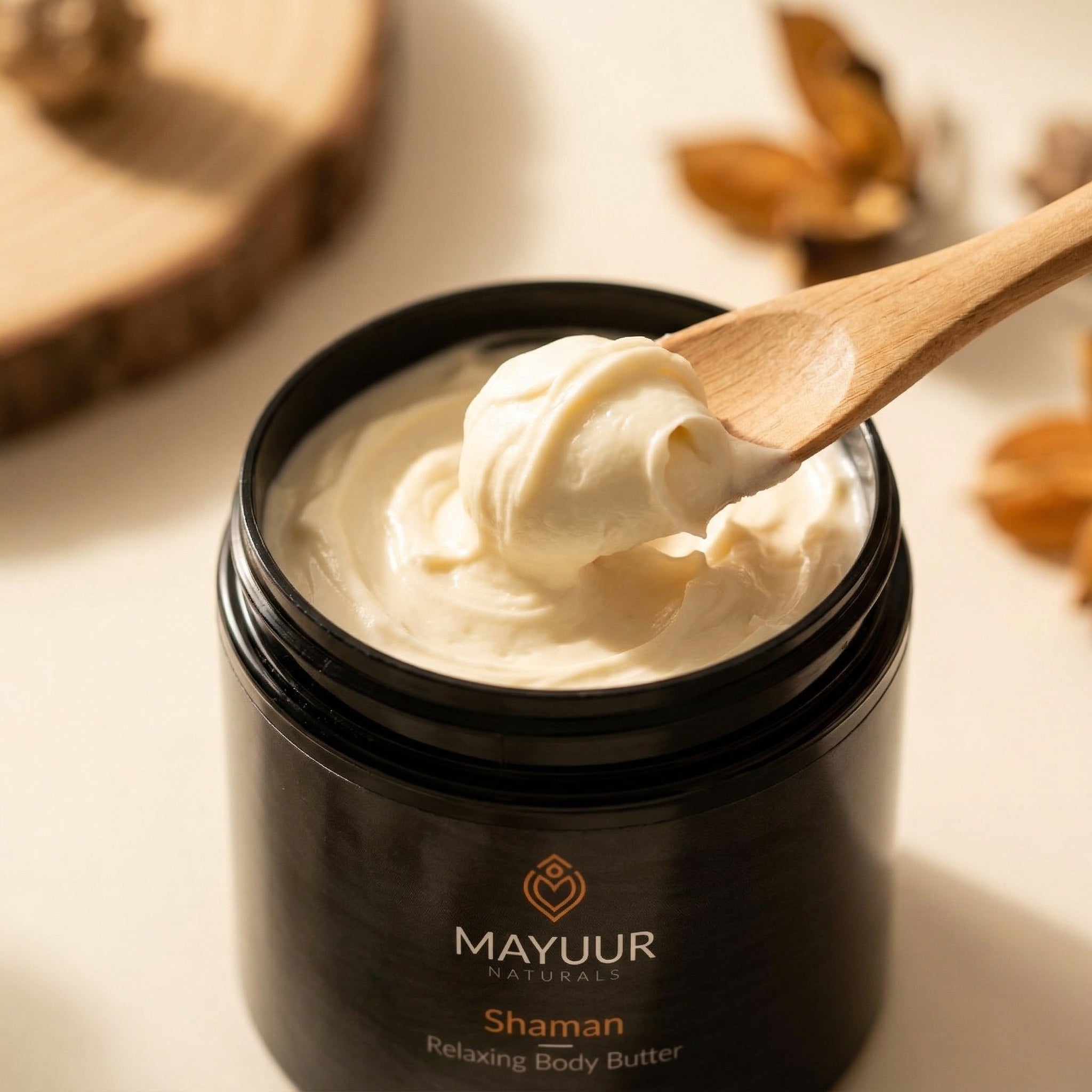 Mayuur Shaman Relaxing Body Butter jar with a wooden spoon scooping out cream.