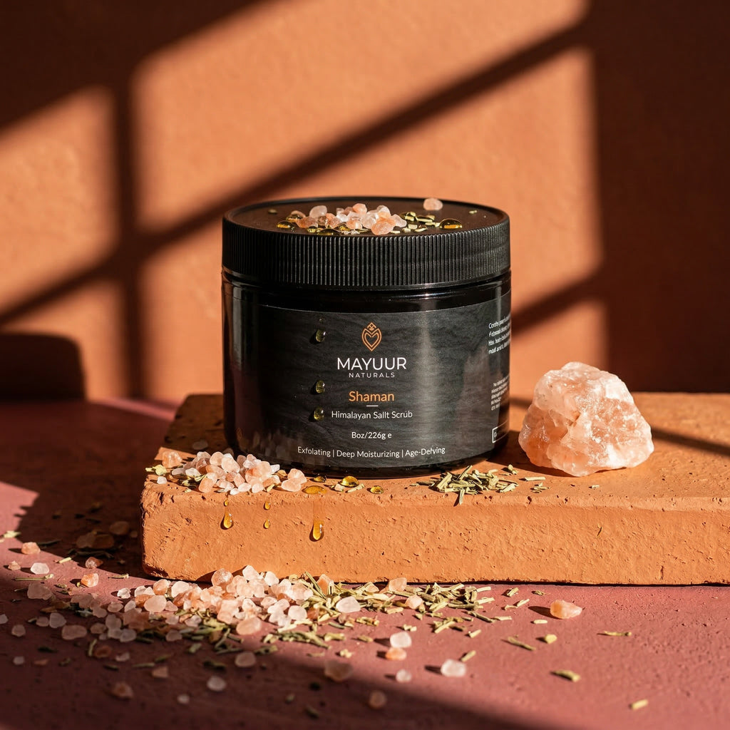 Mayuur Shaman Himalayan Salt Scrub jar on a wooden surface with a rock and salt crystals.