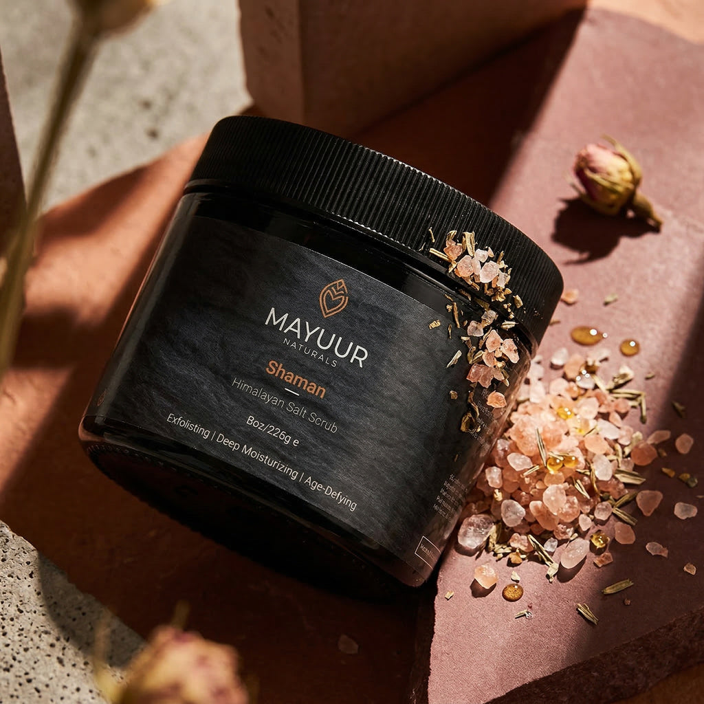 Mayuur Naturals Shaman Himalayan Salt Scrub jar with salt crystals on a textured surface