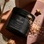 Mayuur Naturals Shaman Himalayan Salt Scrub jar with salt crystals on a textured surface